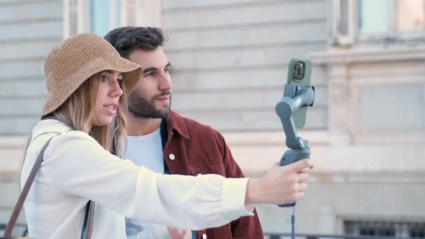 若い白人インフルエンサーカップルは,スペインのマドリード市を観光するソーシャルメディアのためのスマートフォンでビデオを録画. - 映像、動画