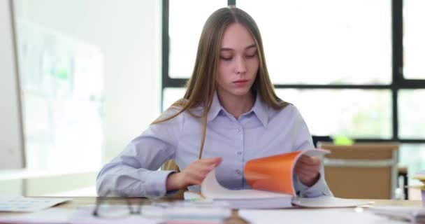 Estudante estagiária feminina gerente folhetos através de diário de entradas no local de trabalho no escritório. Grande caderno ou pasta com documentos nas mãos do gerente nervoso - Filmagem, Vídeo