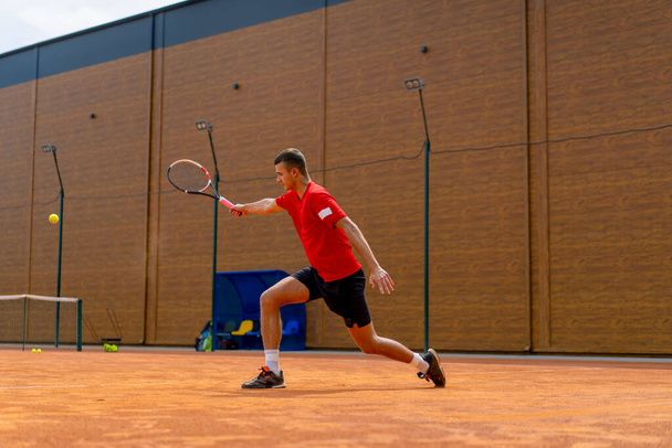 jonge professionele speler coach outdoor tennisbaan oefenen slagen met racket en tennisbal spelen tegen tegenstander - Foto, afbeelding