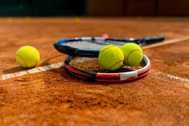 primer plano de los equipos deportivos, raquetas de tenis y pelotas se encuentran una cancha de tierra al aire libre hobby deporte de competición - Foto, Imagen
