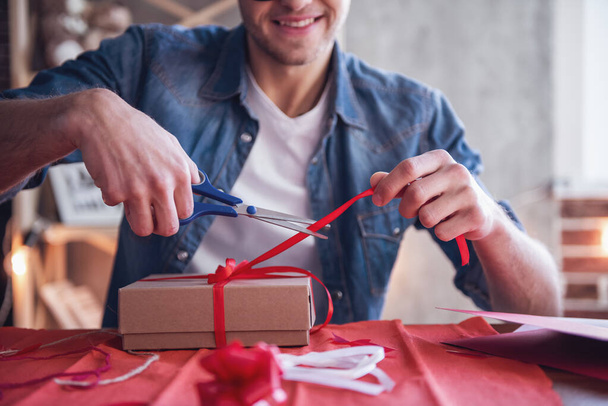 Bello romantico ragazzo sta sorridendo mentre fa regalo per la sua dolce metà
 - Foto, immagini