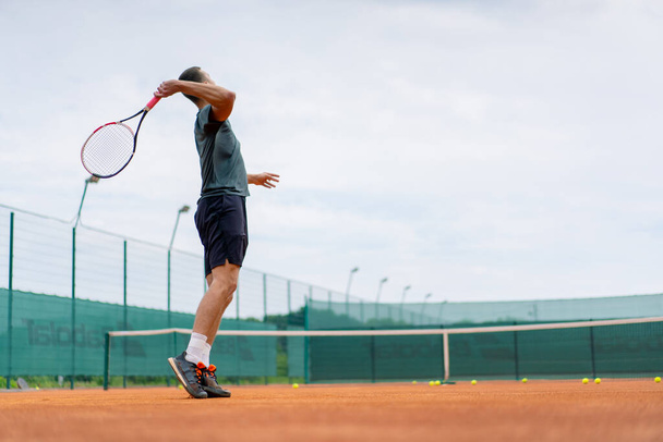 jovem jogador profissional treinador em campos de ténis ao ar livre pratica golpes com raquete bola de ténis - Foto, Imagem