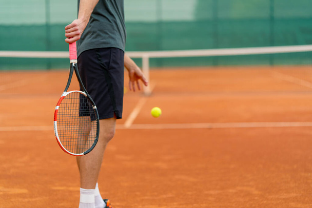 Jungprofi-Spielertrainer übt auf Tennisplatz Schläge mit Schläger-Tennisball - Foto, Bild