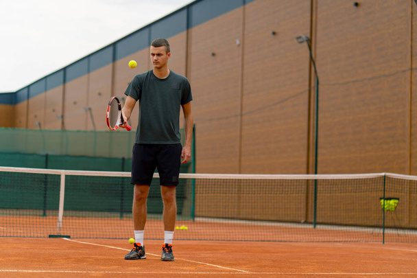 mladý tenista trenér bít míč s raketou na tenisovém kurtu připravuje na soutěž sportovní životní styl - Fotografie, Obrázek