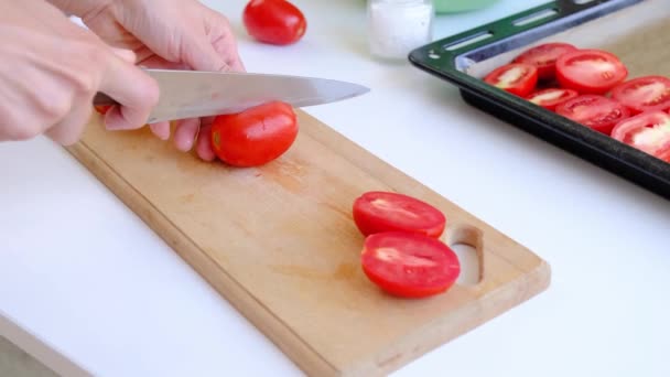 Vue rapprochée des mains de femme coupant des tomates avec un couteau de chefs, au ralenti - Séquence, vidéo