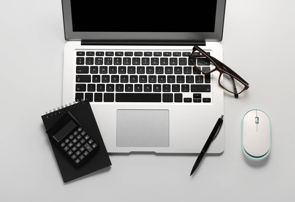 Состав с ноутбуком, калькулятором и очками на белом фоне - Фото, изображение