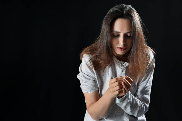 Toxicomane féminine avec seringue sur fond noir - Photo, image