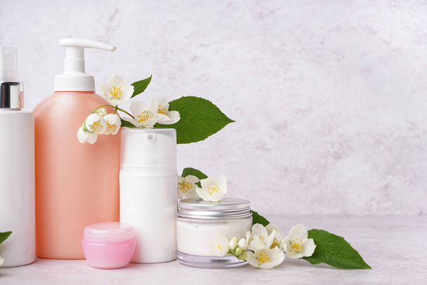 Set de productos cosméticos con hermosas flores de jazmín sobre fondo claro - Foto, imagen