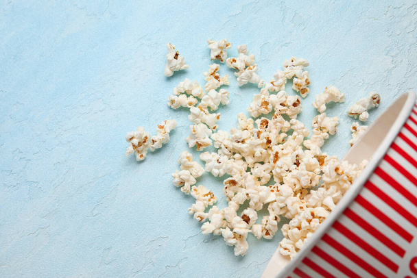 Bucket with tasty popcorn on blue background - Photo, Image
