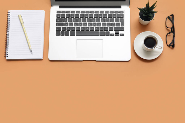 Laptop, xícara de café e papelaria em fundo marrom - Foto, Imagem