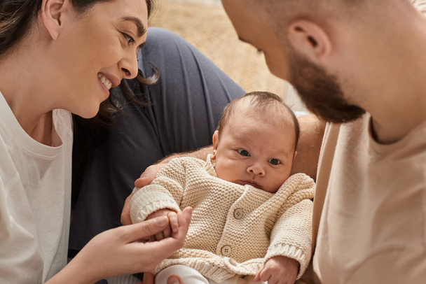 padres modernos alegres pasar tiempo con su bebé recién nacido y sonriéndole, concepto de familia - Foto, Imagen