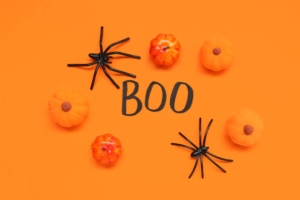 Хеллоуїн композиція з гарбузами, павуками і словом BOO на помаранчевому фоні - Фото, зображення
