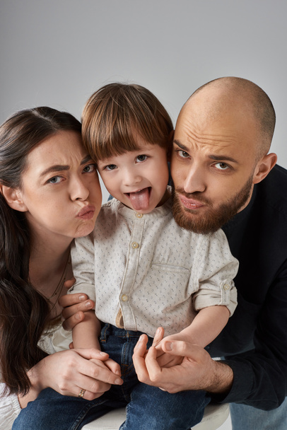famille aimante émotionnelle grimaçant joyeusement à la caméra et se serrant dans ses bras, parentalité moderne - Photo, image