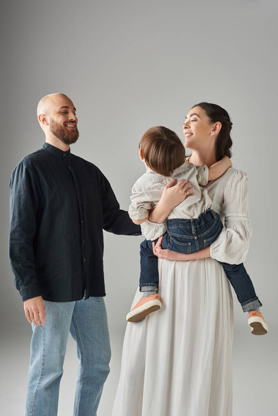 freudiger bärtiger Vater, der seine Frau und seinen Vorschulsohn liebevoll betrachtet, moderne Elternschaft - Foto, Bild