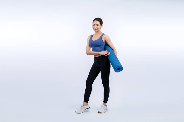 Young attractive asian woman portrait in sportswear with exercising mat. Healthy exercise and workout routine lifestyle concept. Studio shot isolated background. Vigorous - Photo, Image