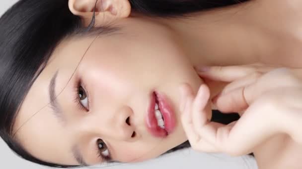 Cerca de la cara de la joven hermosa mujer asiática con la piel sana y fresca. Imágenes de belleza vertical. - Metraje, vídeo