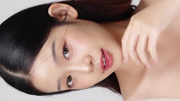 Közelkép fiatal gyönyörű fiatal ázsiai nő egészséges és friss bőr. Függőleges szépségfelvételek. - Felvétel, videó