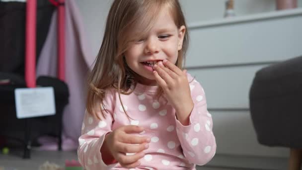 Jedna dívka kavkazské batole dítě jíst makarony těstoviny doma s rukama - Záběry, video