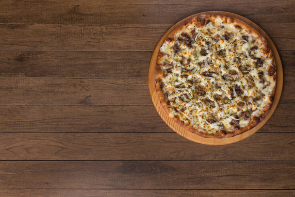 Masová pizza na dřevěné desce. Vyrobeno z mozzarelly, pikanha masa, cibule, sýra, rajčatové omáčky. Filet Steak, maso, horizontální foto shora. - Fotografie, Obrázek