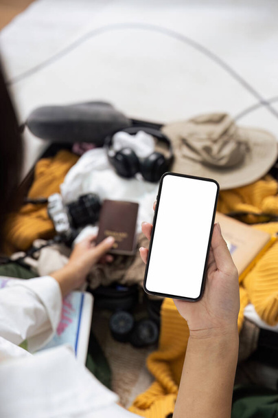 Mockup mobile phone with white screen, luggage in background. - Photo, Image