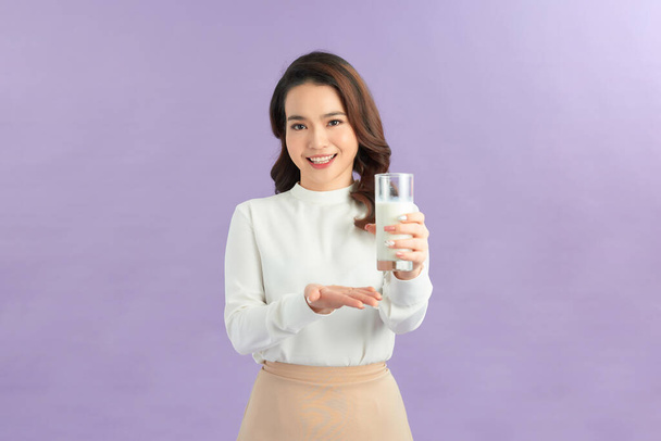 Смеющаяся молодая женщина со стаканом молока
 - Фото, изображение