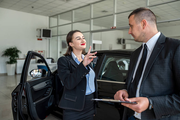 gerente profesional muestra y llevar sobre el coche a cliente femenino en la concesionaria, concepto de compra - Foto, Imagen