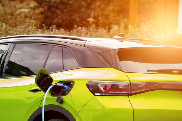 Dom ładujący zieloną drogę. Nowoczesny samochód elektryczny EV ładowania z energii odnawialnej. Montowana na ścianie stacja ładowania pojazdów elektrycznych dla zrównoważonego transportu pojazdów elektrycznych - Zdjęcie, obraz