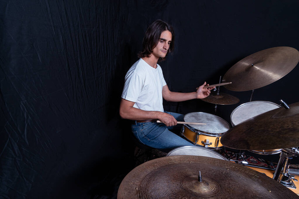 Mann spielt Schlagzeug. Live-Musik Hintergrundkonzept. Schlagzeuger und Rockmusik, Studio im Schwarzhintergrund gedreht. - Foto, Bild