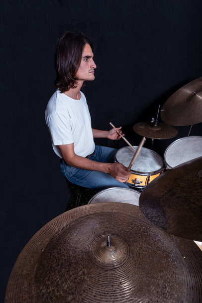 Человек, играющий drum.Live музыкальный фон, задуманный как Drum.Live и рок-музыка, студийный снимок на черном фоне. - Фото, изображение