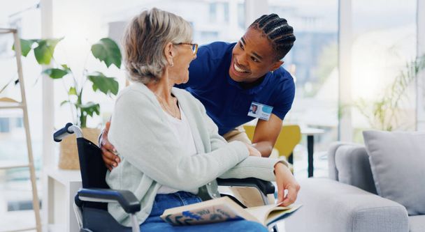 Black man, caregiver or old woman in wheelchair talking or speaking in homecare rehabilitation together. Medical healthcare advice or male nurse nursing or helping elderly patient with disability. - Photo, Image