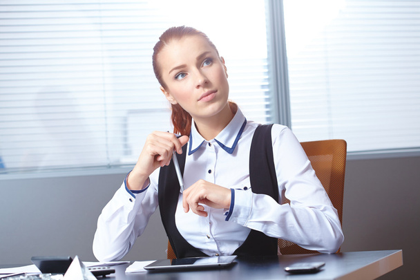 Young businesswoman sitting at workplace - Valokuva, kuva