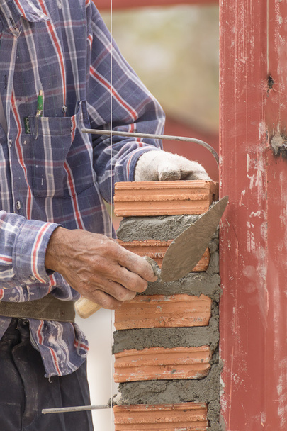 Tijolo trabalhando em canteiro de obras de parede de tijolo
 - Foto, Imagem