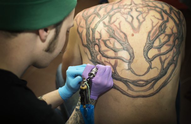 Татуйований чоловік робить татуювання
 - Фото, зображення