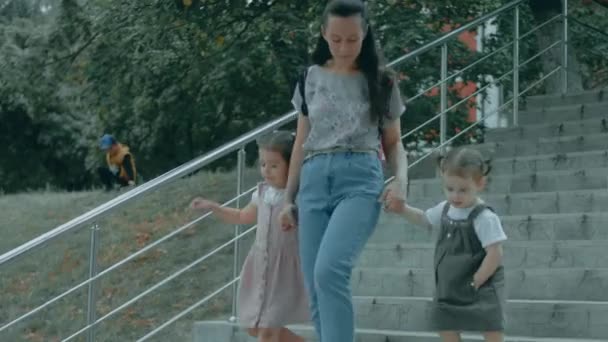 愛する子供たちよ。 幼稚園の娘と幼稚園の娘と一緒に階段を歩いているハッピーな母親. いい散歩をする. 母 と 娘 時間 - 映像、動画