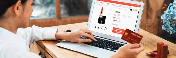 Woman shopping online on internet marketplace browsing for sale items for modern lifestyle and use credit card for online payment from wallet protected by uttermost cyber security software - Photo, Image