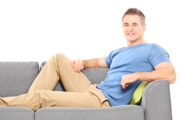 Young man sitting on sofa - 写真・画像
