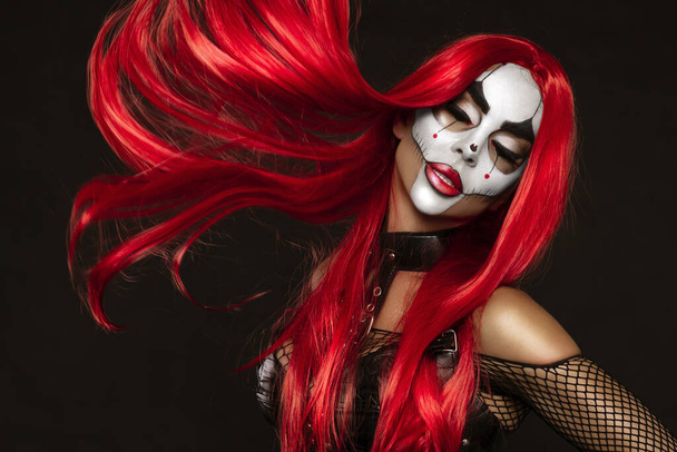 Mujer sexy en un maquillaje de Halloween y traje sobre fondo negro. Halloween maquillaje y vestuario concepto. - Foto, Imagen