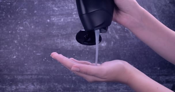 女性の手のひらに注がれた黒いボトルで体を洗浄します. 新鮮で清潔で,シャワーゲルで活性化した肌. スキンケア,健康,衛生コンセプト。 スローモーション 4k - 映像、動画