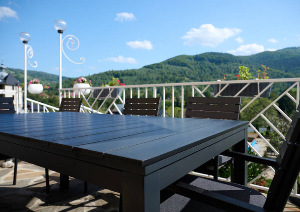 Ângulo largo, vista para o terraço com uma mesa e um guarda-chuva do sol. Apartamento para descansar nas montanhas. Resort em montanhas dos Cárpatos. - Foto, Imagem