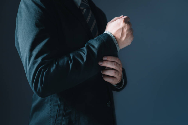 Портрет бизнесмена в костюме, стоящего вдумчиво, полуживого и не показывающего лица - Фото, изображение