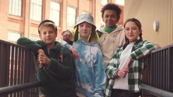 Retrato de lentitud media de diversa compañía de adolescentes posando para la cámara fuera de la escuela en verano - Imágenes, Vídeo