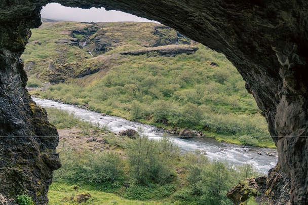 Ποταμός όπως φαίνεται από το σπήλαιο Pvottahellir στο μονοπάτι καταρράκτη Glymur, Ισλανδία - Φωτογραφία, εικόνα