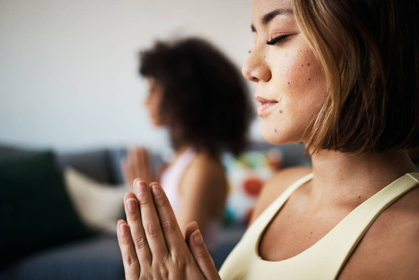 Frauen, Fitnessfreunde und Meditation mit Gebet für Achtsamkeit, Wohlbefinden und Seelenfrieden zu Hause. Yoga, spirituell und ruhig in der Lounge mit Heilung und Zen, namaste mit Bewegung und Selbstpflege. - Foto, Bild