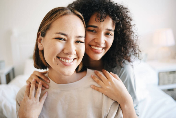 Smile, happy and portrait of lesbian couple on bed for bonding, resting or relaxing together on weekend. Love, romance and young interracial lgbtq women in the bedroom of modern apartment or home - Foto, Imagen