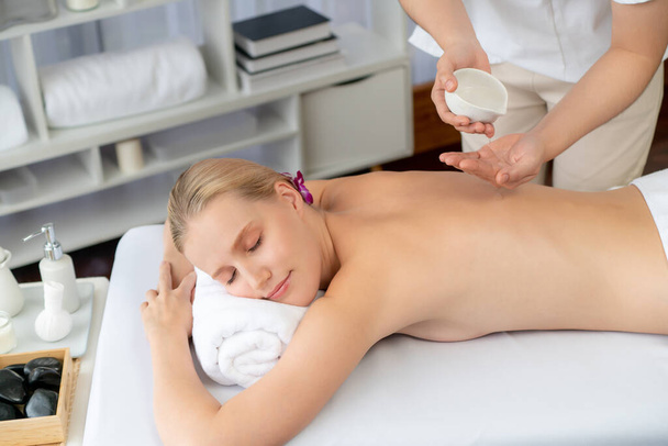 Masseur hands pouring aroma oil on woman back. Masseuse prepare oil massage procedure for customer at spa salon in luxury resort. Aroma oil body massage therapy concept. Quiescent - Photo, Image