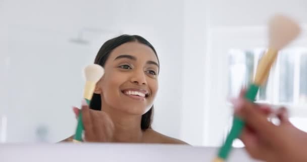 Макияж, красота и молодая женщина в ванной комнате для гламура, естественный или лицо рутины в зеркале. Косметология, кисть и индийская женщина, делающая косметические процедуры с помощью инструмента в современной квартире - Кадры, видео