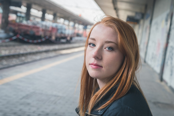 Beautiful girl posing in a railroad station - Фото, зображення