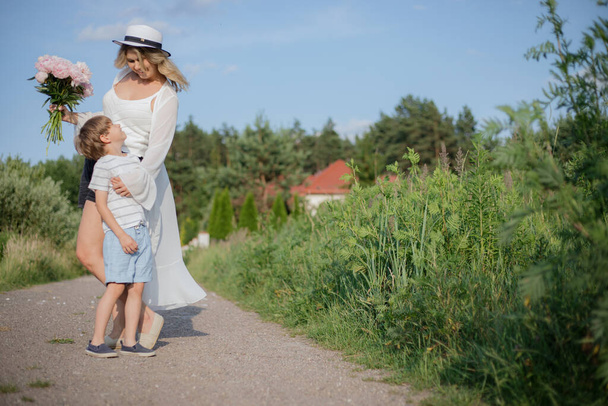 Mutlu anne ve oğul yaz günü doğada kırsal yolda yürürken birbirlerinin keyfini çıkarıyorlar. Olumlu duygular. Anne tatili. Bekar ebeveynler. Mutlu bir çocukluk. Aile ilişkileri.  - Fotoğraf, Görsel