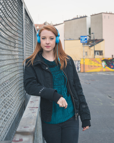 Menina bonita com fones de ouvido posando nas ruas da cidade
 - Foto, Imagem