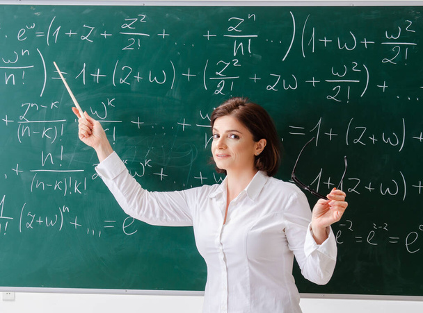A női matektanár a tábla előtt. - Fotó, kép